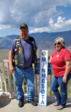 In September 2021, Brad and Patricia Pagel stand in front of the Grand Canyon with a Minnesota sign from the 102nd National Convention in Phoenix.