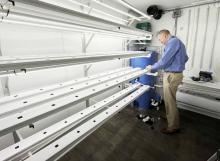 MCC Principal Jake Scandrett checks the water flow in a trough in the Grow Shed.