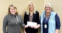 Julie Dahlhoff (center) of MBFC presents Reality Check volunteers Kim Hause and Justine Wettschreck with a $1,500 check to help fund the budgeting program for high school seniors at MCC and Fulda.