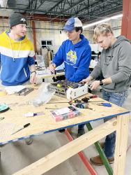 SDSU Robotics Club members, from left, Keegan Visher, Connor Olson and Maverick Beckmann work on the assembly of a 30-pound robot, nicknamed “Roadkill,” which they will enter in a collegiate combat robotics contest March 18. The club has received a $10,000 grant to help its robot-building efforts.