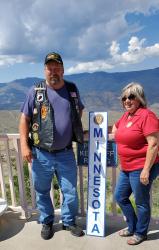 In September 2021, Brad and Patricia Pagel stand in front of the Grand Canyon with a Minnesota sign from the 102nd National Convention in Phoenix.
