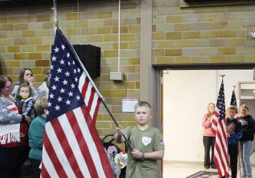 Fourth grade students at MCC carry in flags