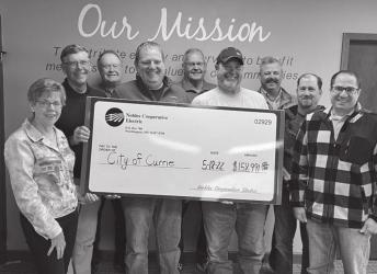 Currie Firemen Lucas Radke and Jeff Zens accept the funds from the NCE Board of Directors.