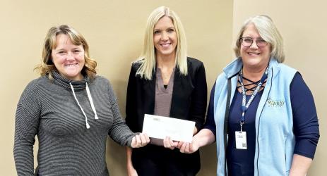 Julie Dahlhoff (center) of MBFC presents Reality Check volunteers Kim Hause and Justine Wettschreck with a $1,500 check to help fund the budgeting program for high school seniors at MCC and Fulda.