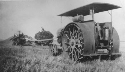 Herman Onken was an enterprising man. Along with farming, he shelled corn and did threshing. This machine is his Altman Taylor gas driven threshing machine. His son Vernon is standing on the machine.