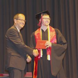 Fulda School Board member Loren Carlson presented graduating seniors their diplomas during Commencement on Friday night. He is pictured to the left with graduate Tyson Clausen.