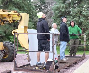 Eric Cox and Cole Hennen, Western Print Group, discuss Fulda Heritage Museum sign placement with Randy Dierks and Ted Winter.